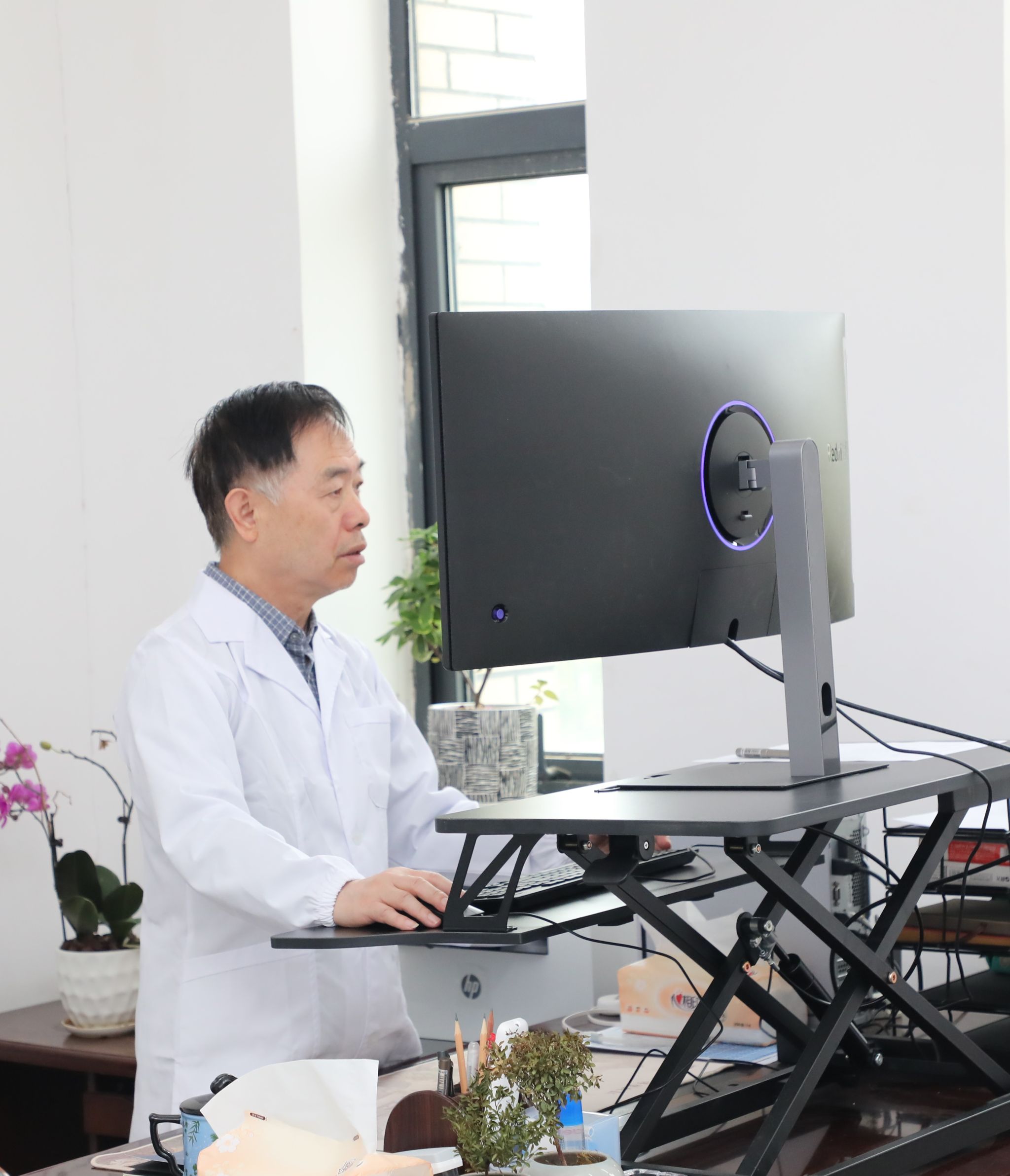 腰椎不好，武汉大学帮扶贵州师范老员工物学学科领队孙蒙祥教授站着办公。薄文鹤 摄